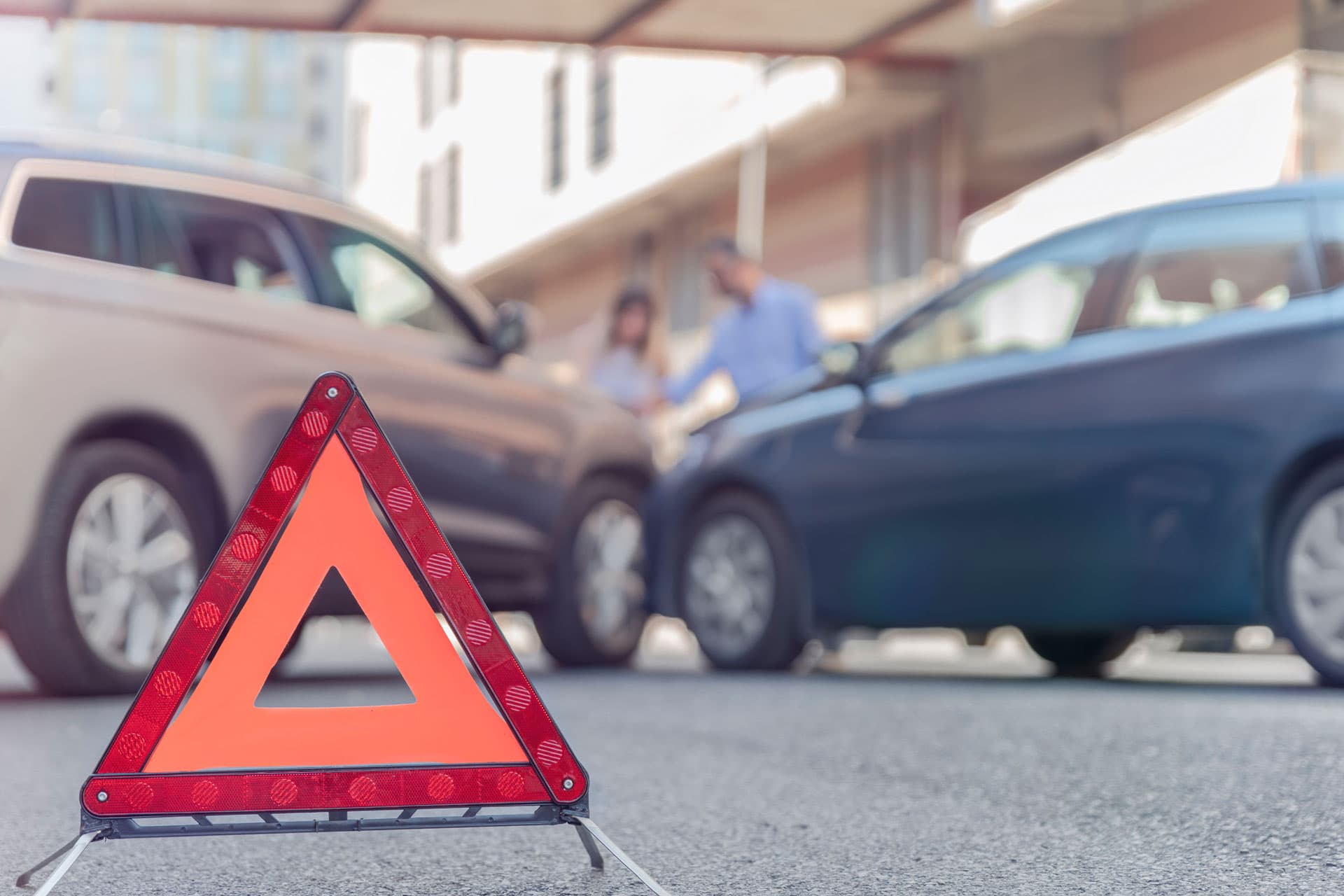 Warndreieck vor zwei Autos nach einem Unfall